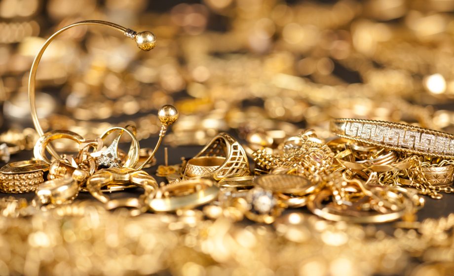 Table of scrap gold being inspected.Focal point on the two bracelets.